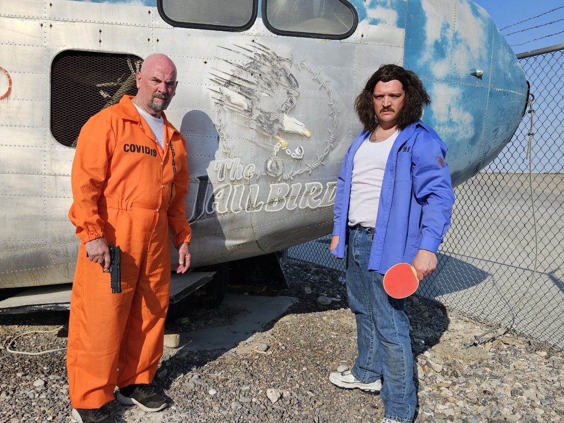 Two actors in costume in front of the retired Con Air aircraft