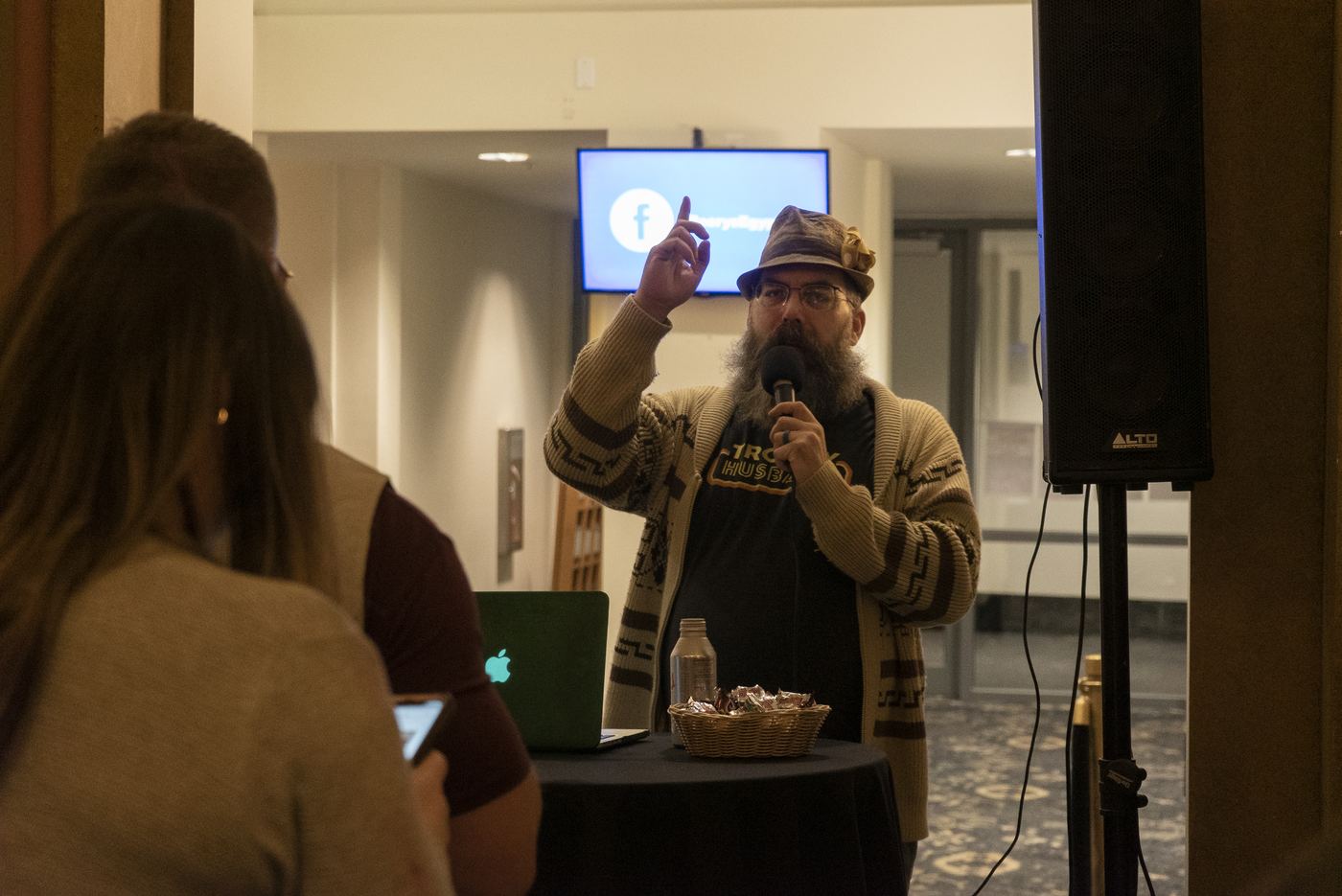 Festival host speaking into a microphone in the theater lobby