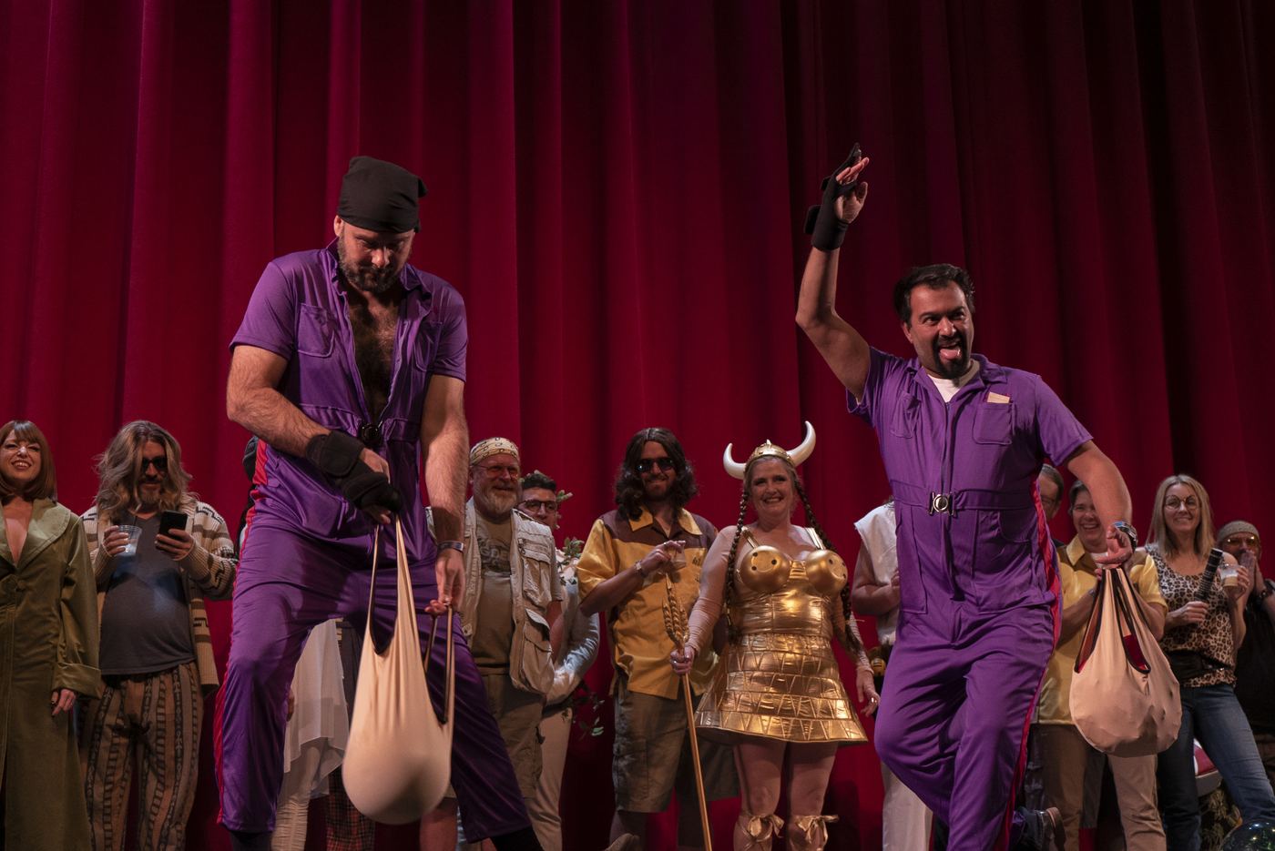 Nihilists in purple jumpsuits on stage