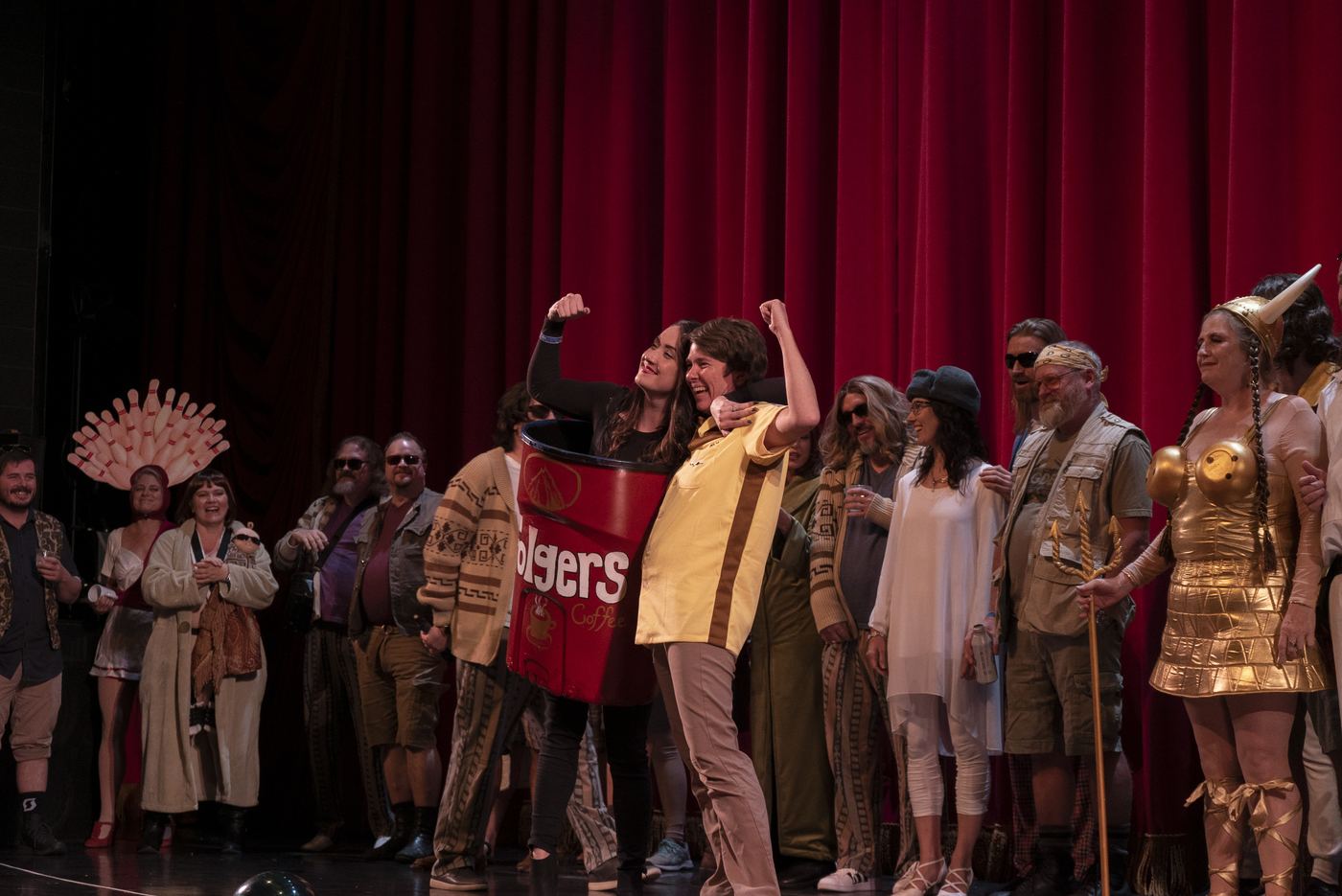 Winners dressed as a Folgers can and a bowler celebrating on stage