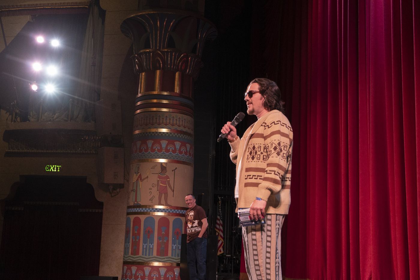 The Dude speaking into a microphone on stage at Peery's Egyptian Theater