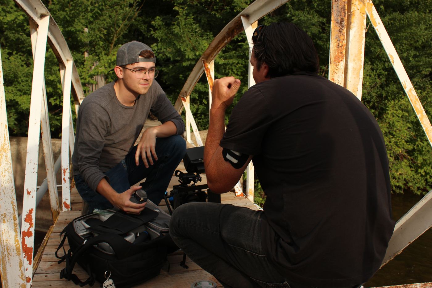 Crew reviewing footage on an old bridge location