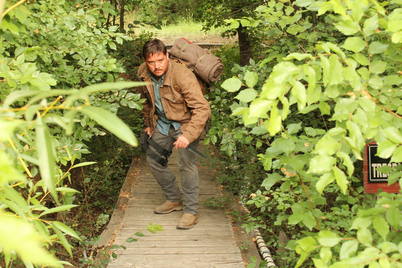 Actor in character on a wooded trail