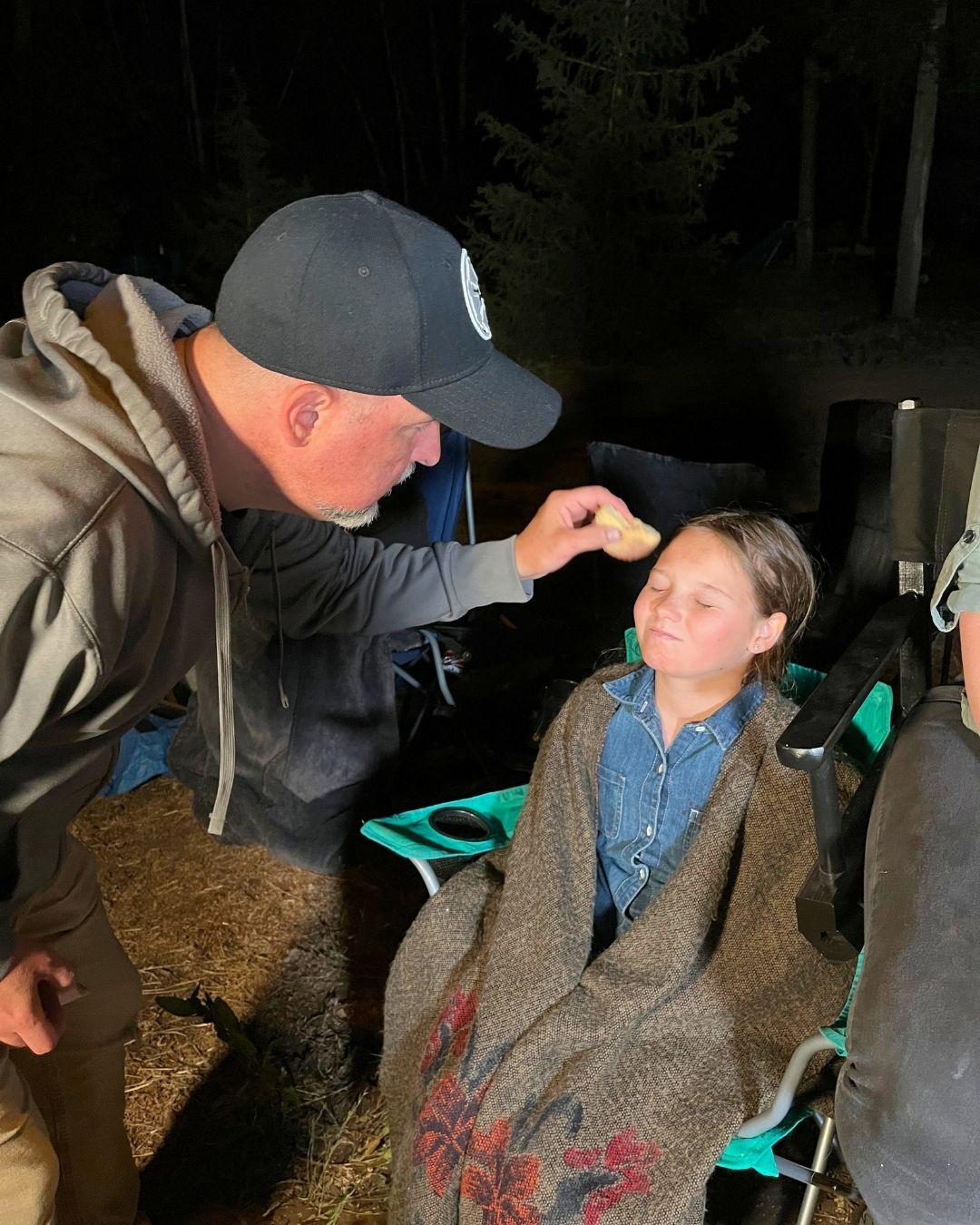Shawn Gordon applying makeup effects to an actor on set at night